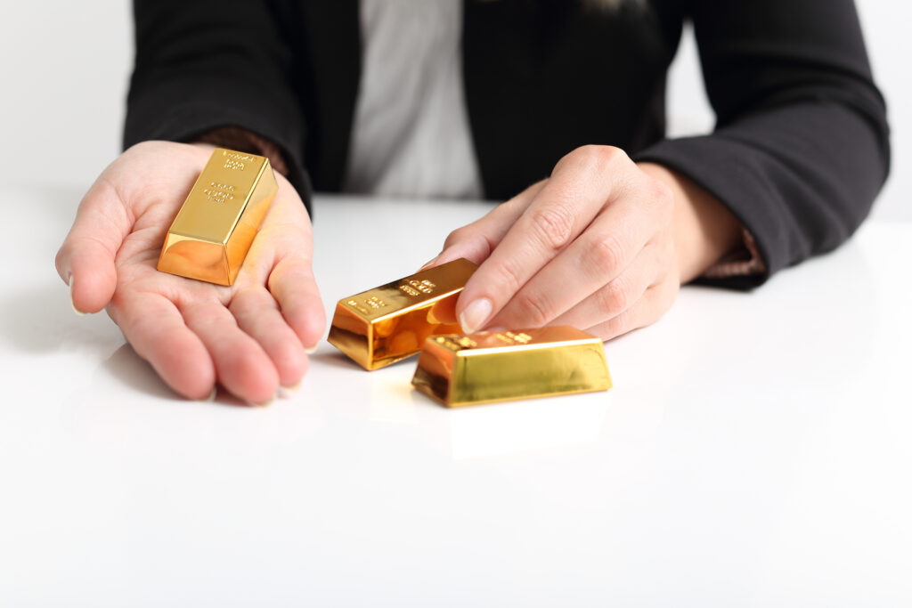 Beraterin hält Goldbarren bei der Wertermittlung