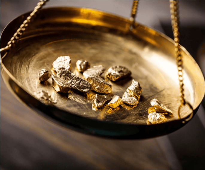 Altgold und Goldnuggets auf einer Waagschale